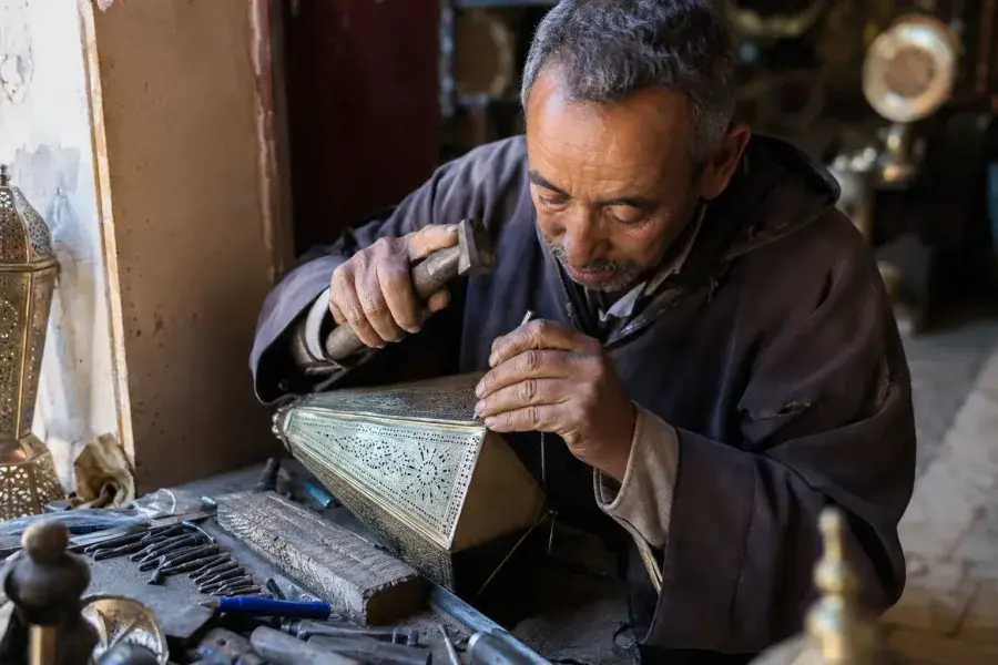 Marrakech artisan demonstrating traditional craftwork in the souks