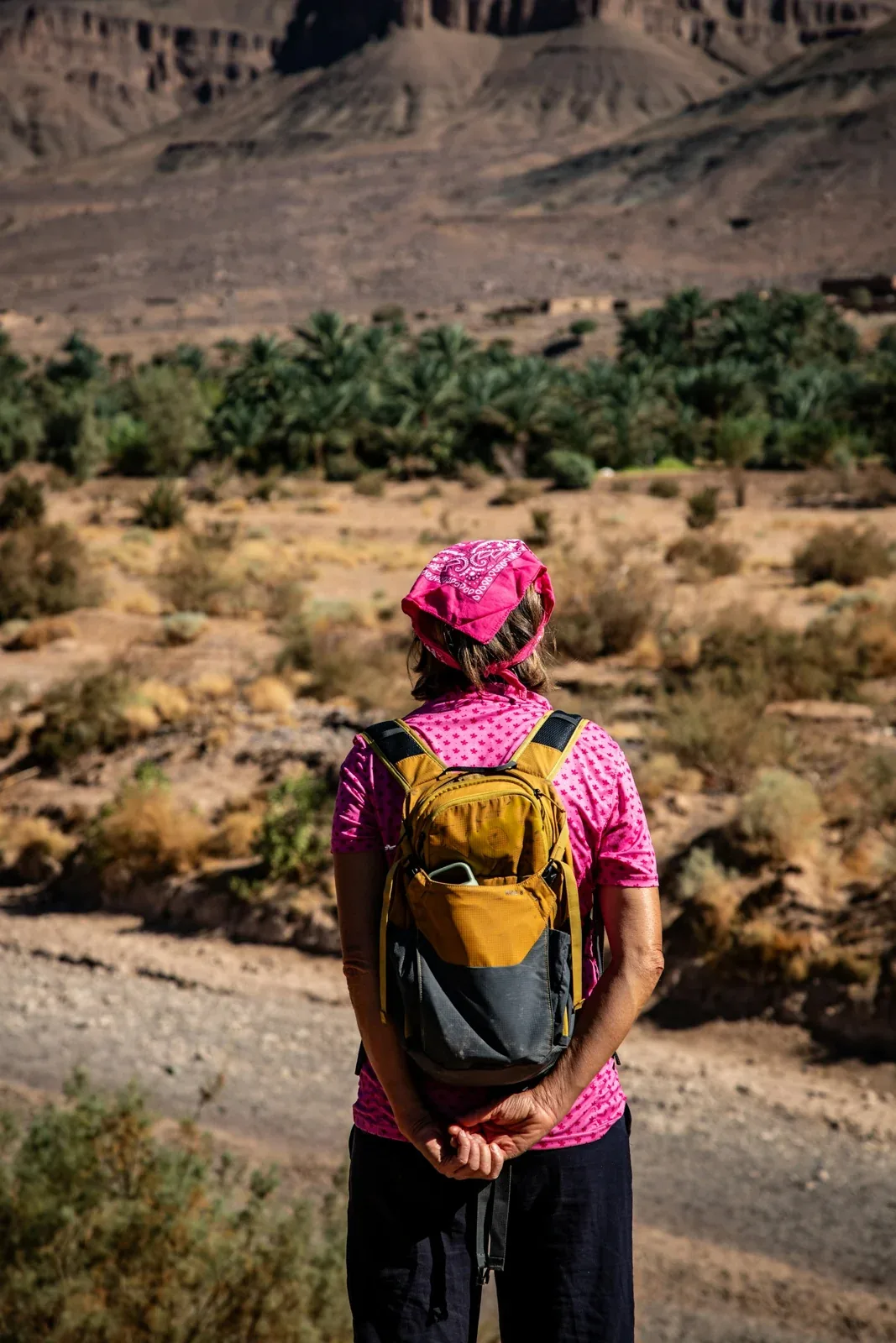 Reisende mit kleinem Rucksack in einer marokkanischen Wüstenlandschaft