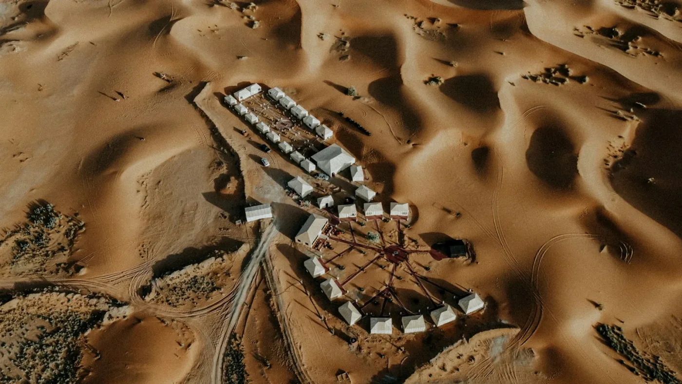 Aerial view of tents arranged among the dunes near Merzouga