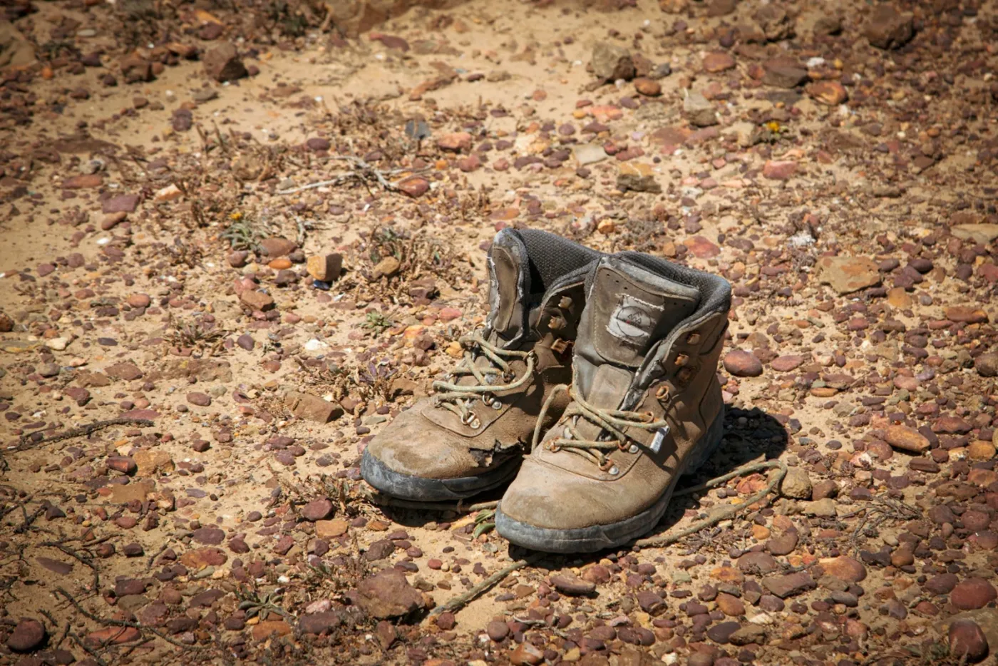 Botas de marcha usadas sobre terreno seco y pedregoso