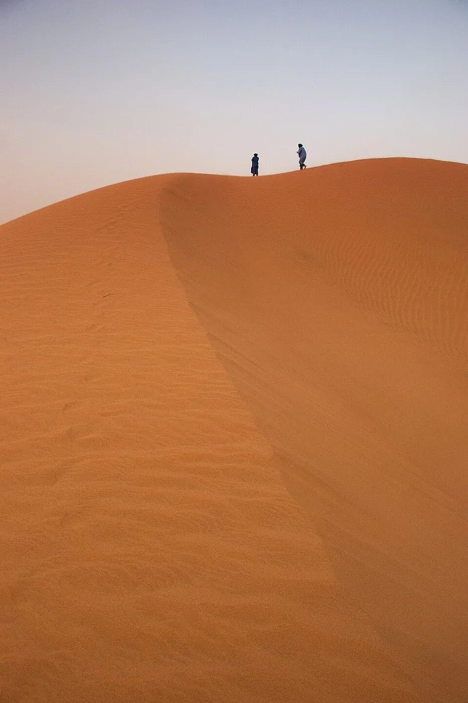 Dos caminantes en una duna de Erg Lehoudi cerca de M’Hamid