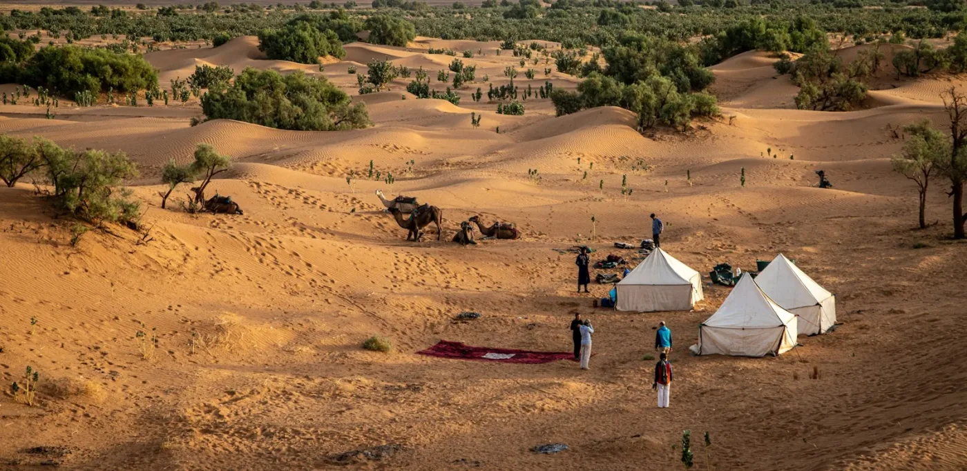 Tentes et voyageurs dans un campement du désert marocain