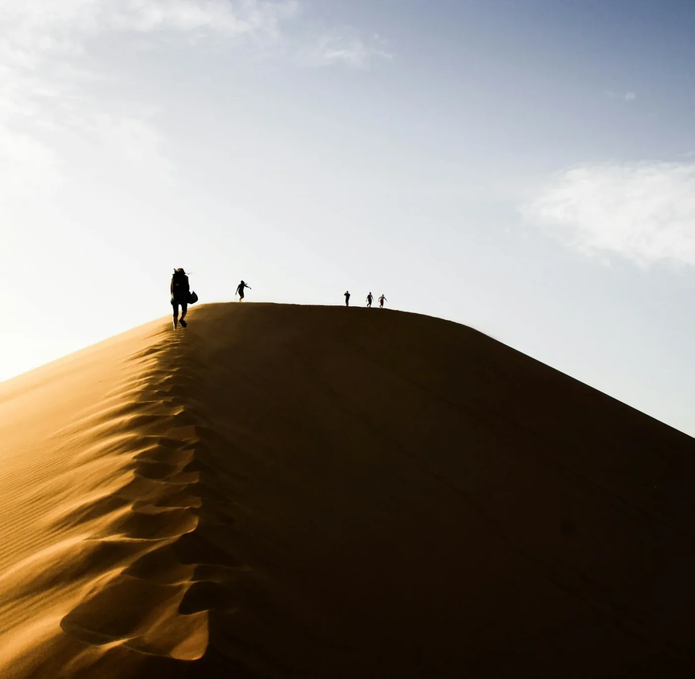 Marcheurs sur une dune marocaine en plein soleil