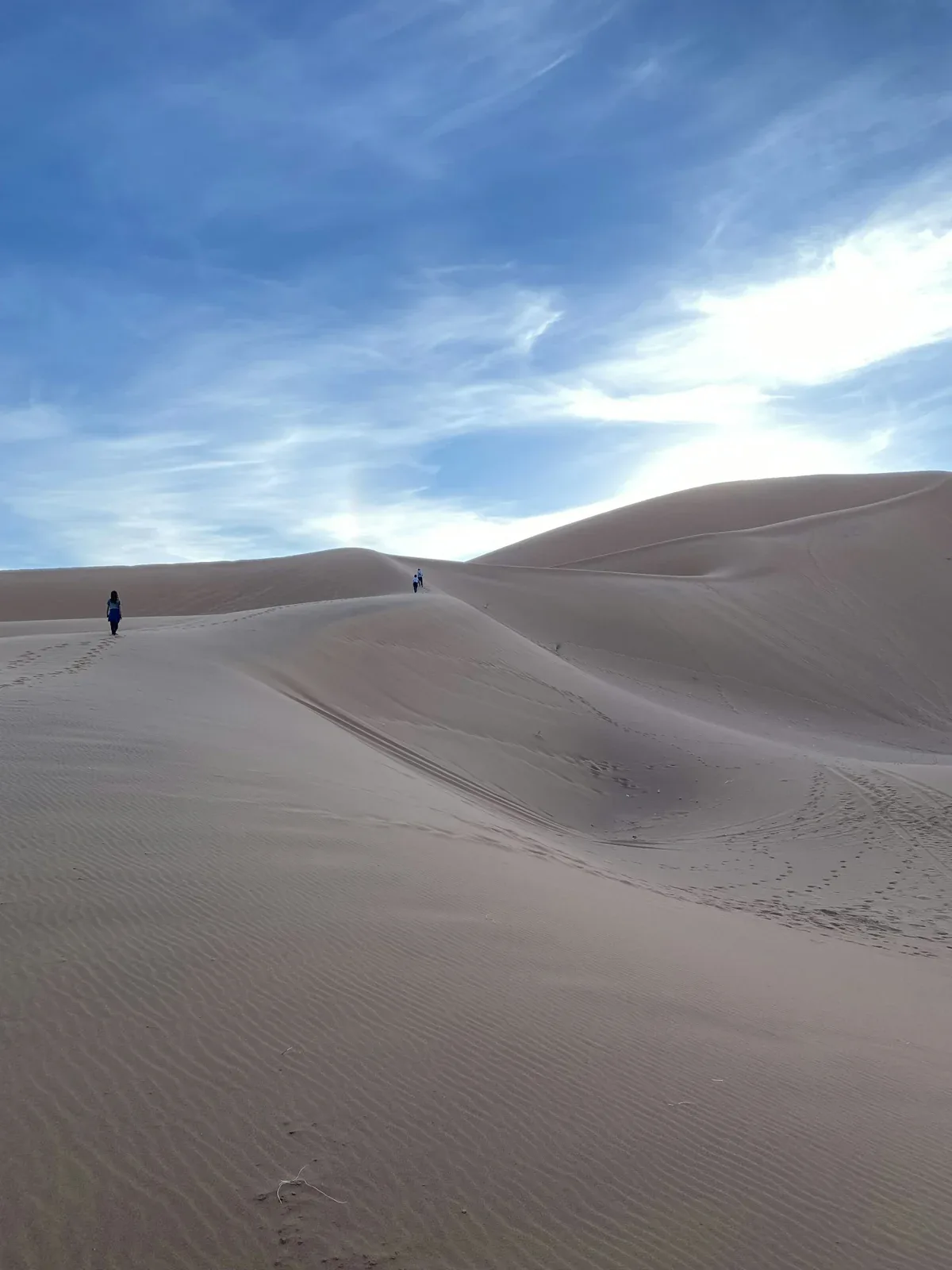 Personne marchant seule sur des dunes claires près de M’Hamid