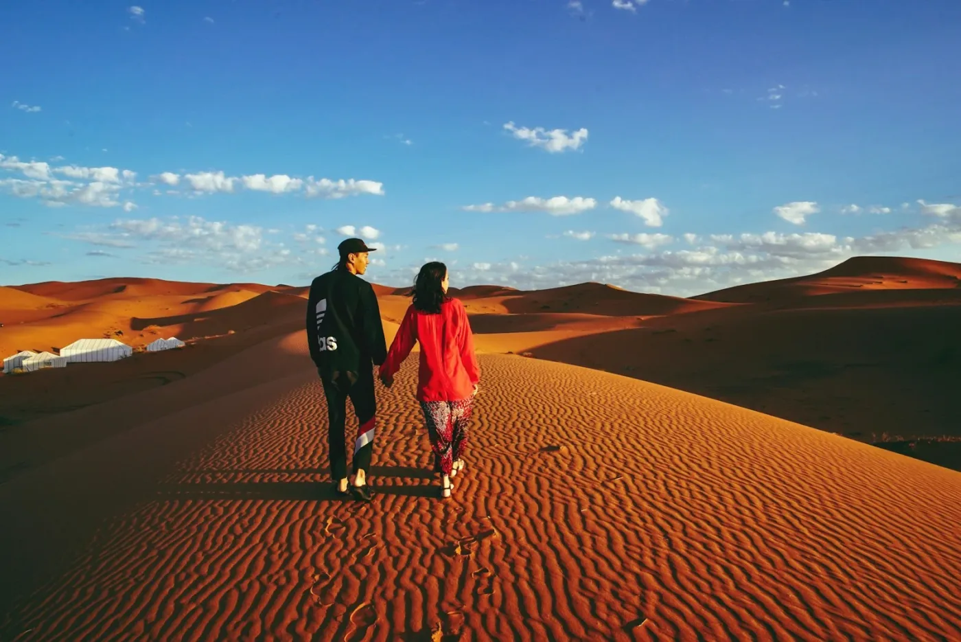 Voyageurs marchant dans les dunes de l’Erg Chebbi près de Merzouga