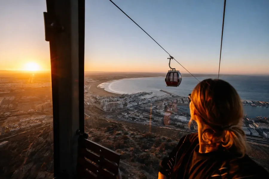 Cable car ascending above Agadir with the Atlantic bay at sunset