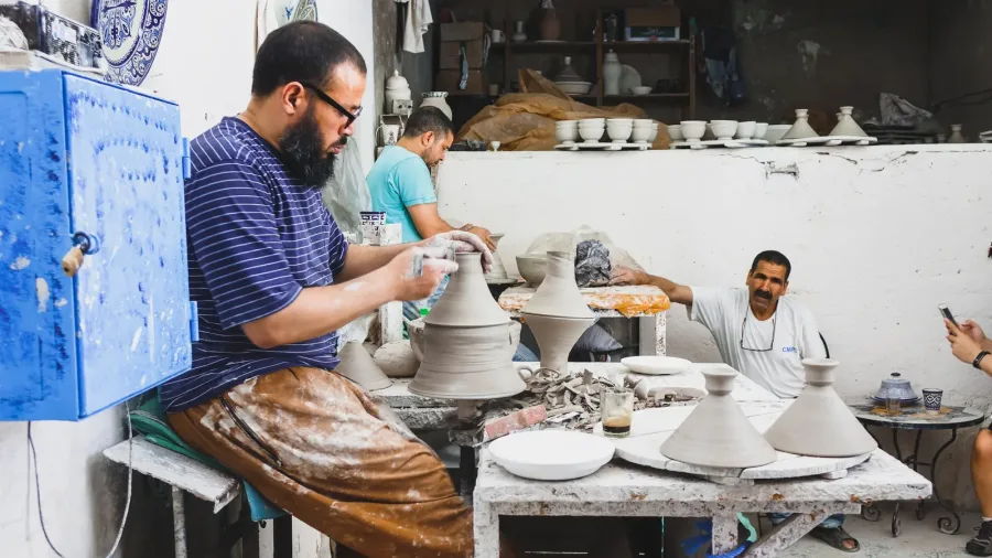 Fes artisan shaping a clay vessel on a potter's wheel