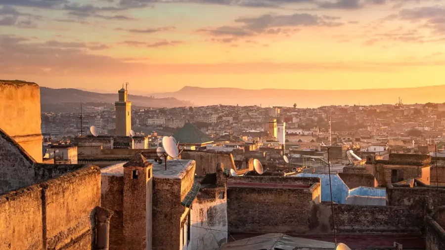 Golden sunset illuminating the rooftops and minarets of Fes Medina