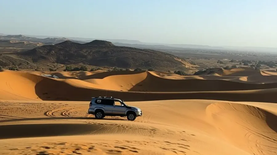 Four-wheel-drive vehicle crossing dunes near Merzouga