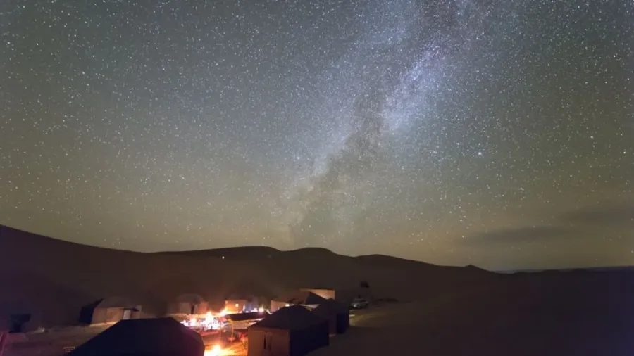 Sahara tents and campfire beneath the Milky Way at Erg Chigaga