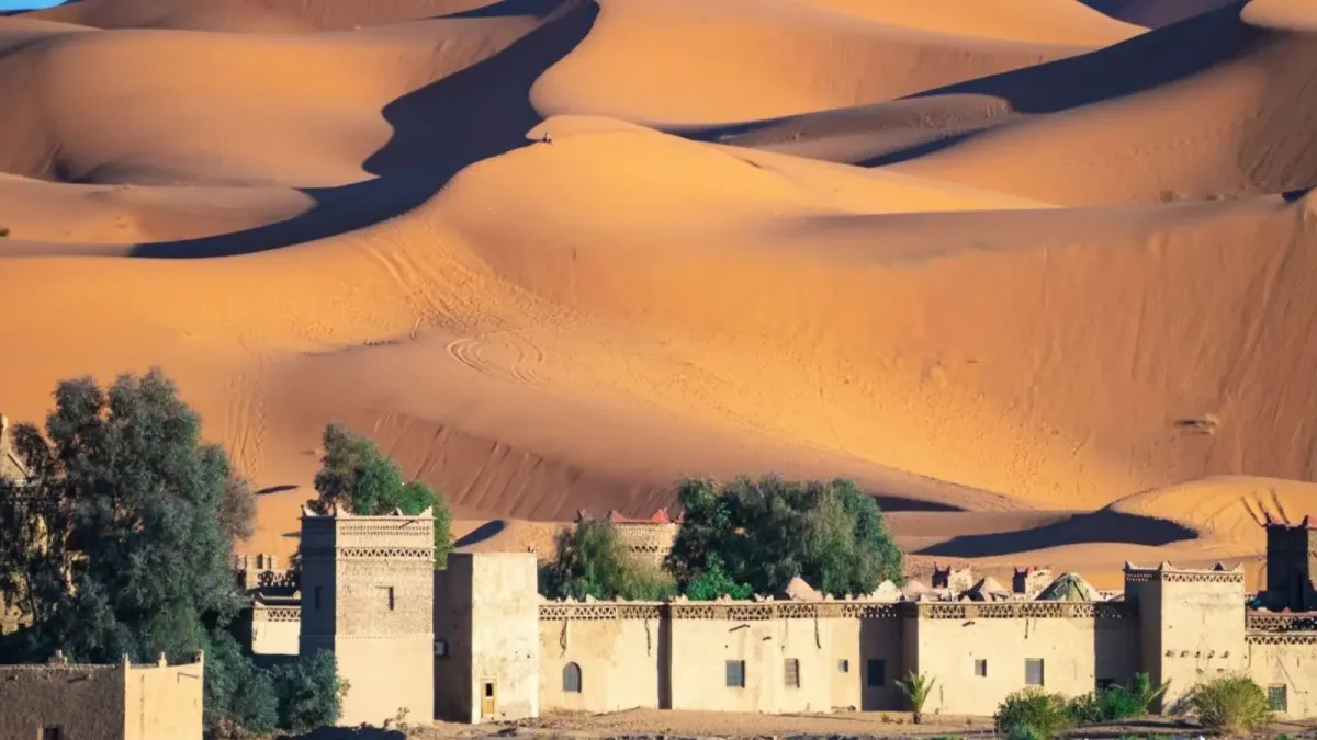 Scopri Merzouga, porta delle dune dorate di Erg Chebbi, con campi nel deserto, trekking in dromedario, oasi e musica di Khamlia.